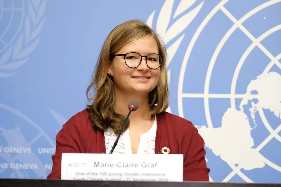 Portrait Marie-Claire Graf UN Hintergrund blau Podium